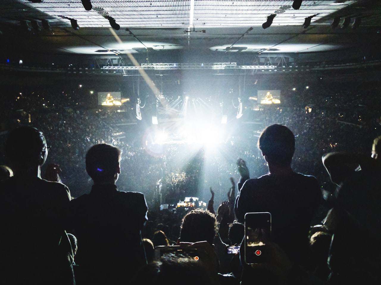 Stadium concert crowd under stage lights